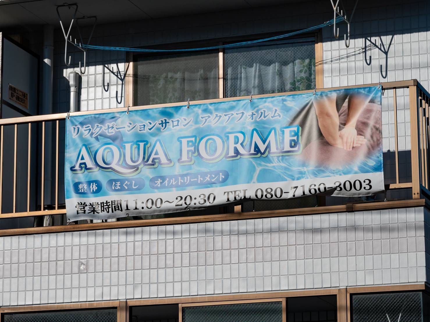建物の目印となる青いAQUA FORMEの横断幕。営業時間は当ページの案内をご確認ください